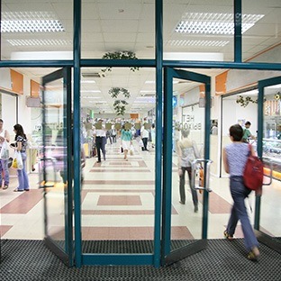 shoppers walking through glass doors